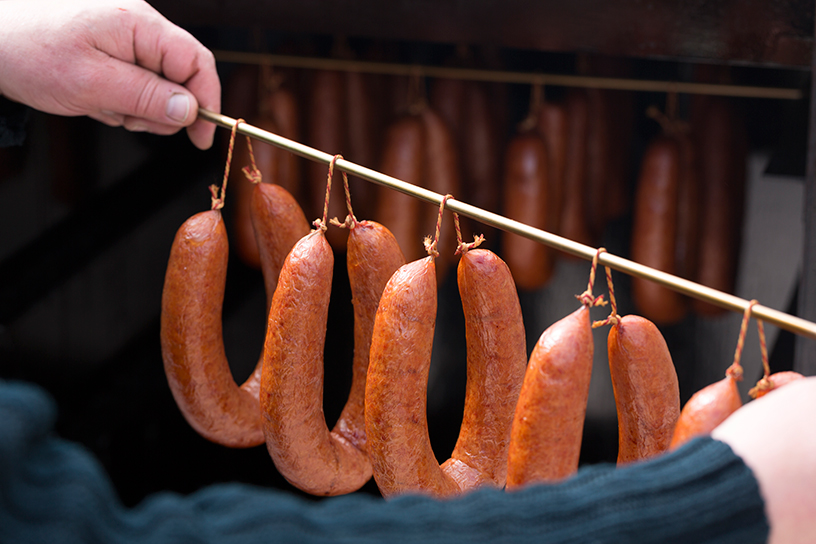 rookworsten hangend aan een stok